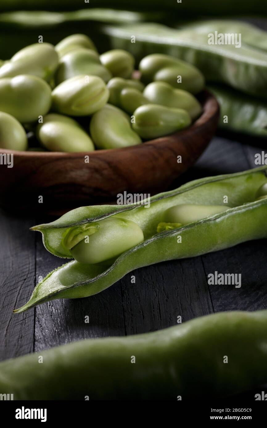 Fresh picked broad beans on a wooden table. Stock Photo