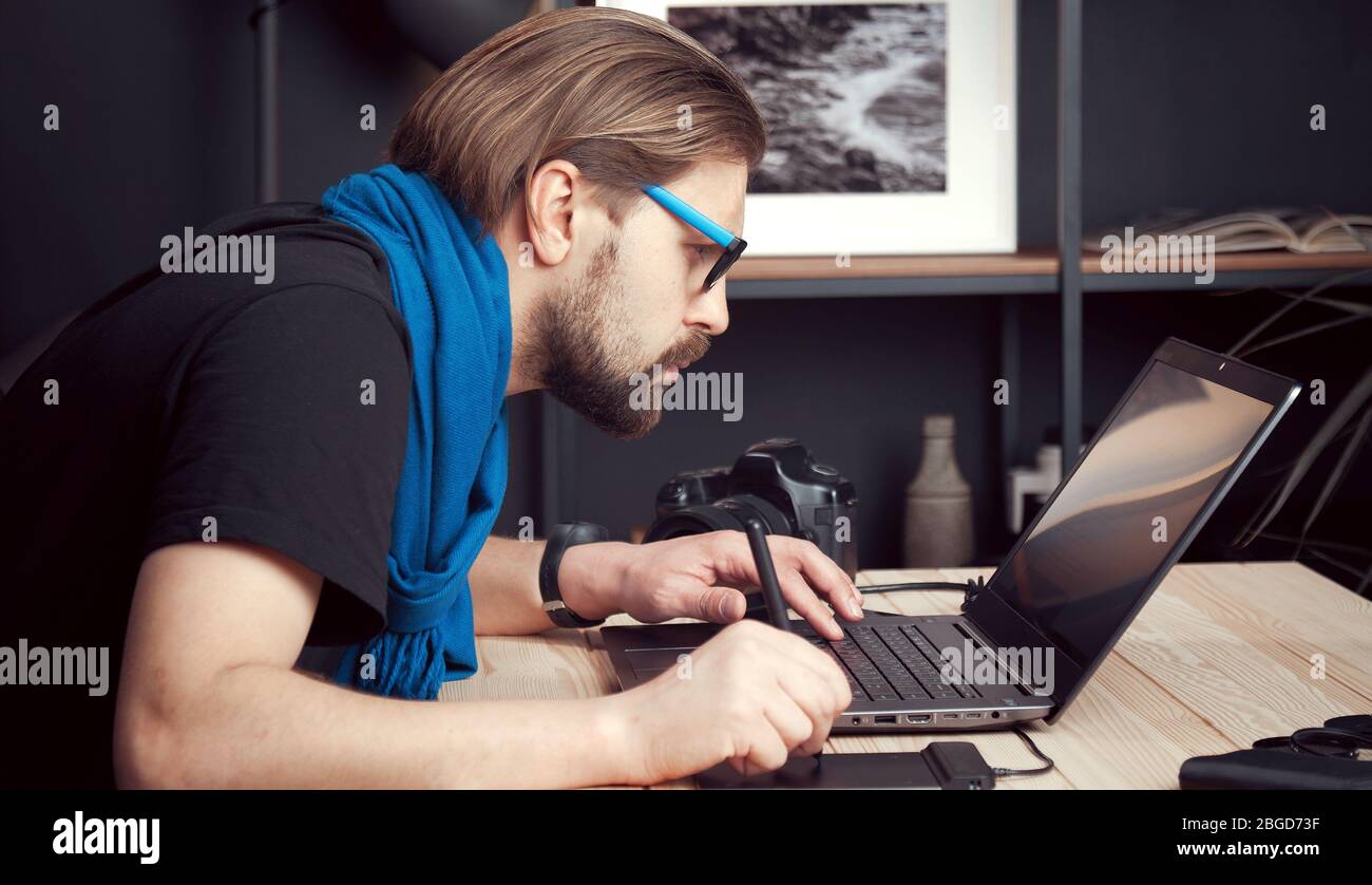 Photographer processing images, side view Stock Photo