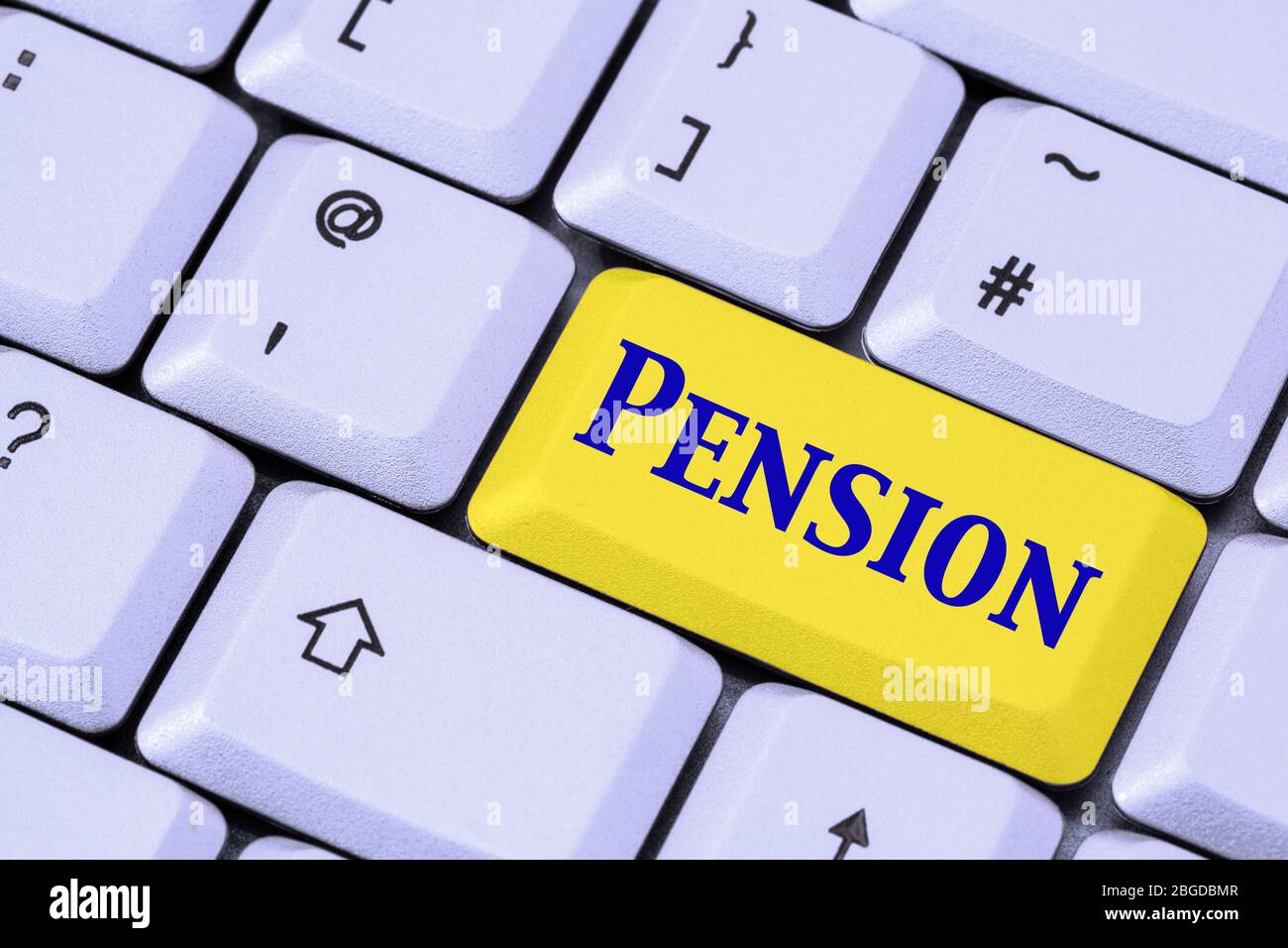 A keyboard with the word PENSION in blue lettering on a yellow enter key. Business and retirement concept. England, UK, Britain Stock Photo