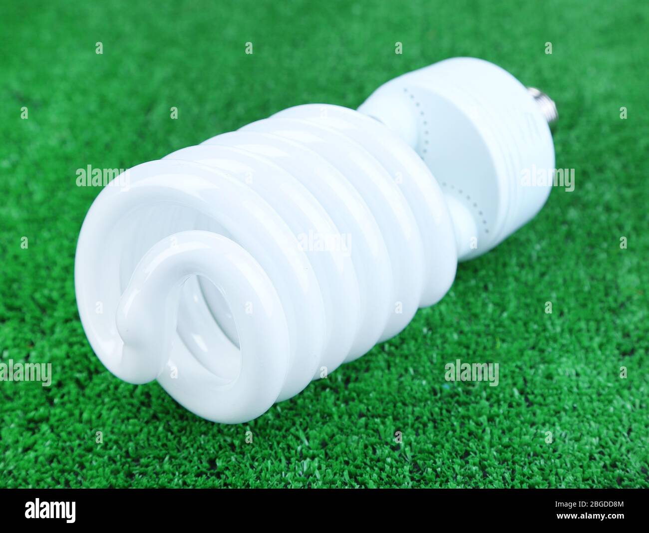 Energy saving light bulb on green grass background Stock Photo - Alamy