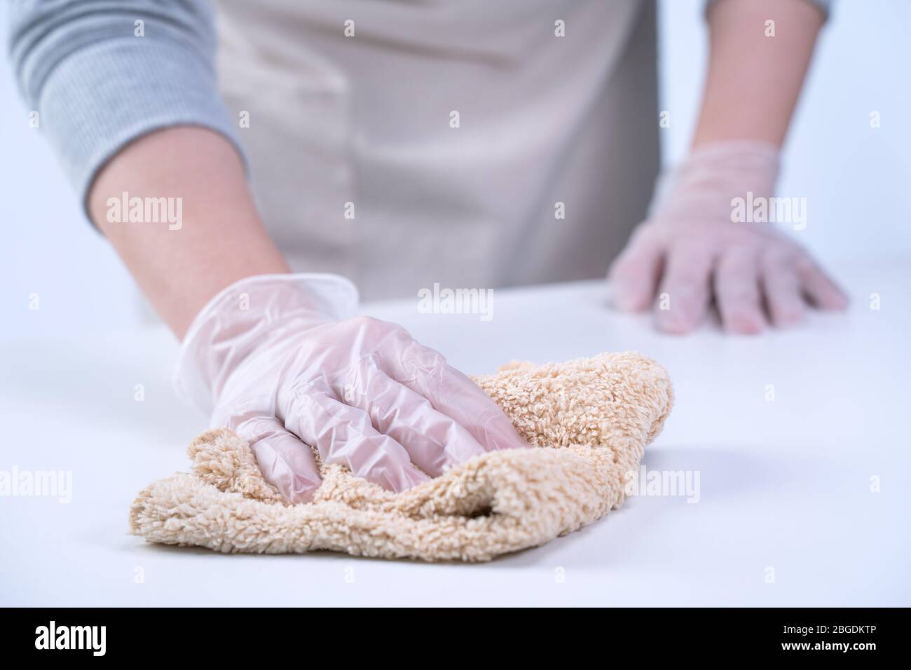 Young woman housewife is cleaning, wiping down home table surface to ...