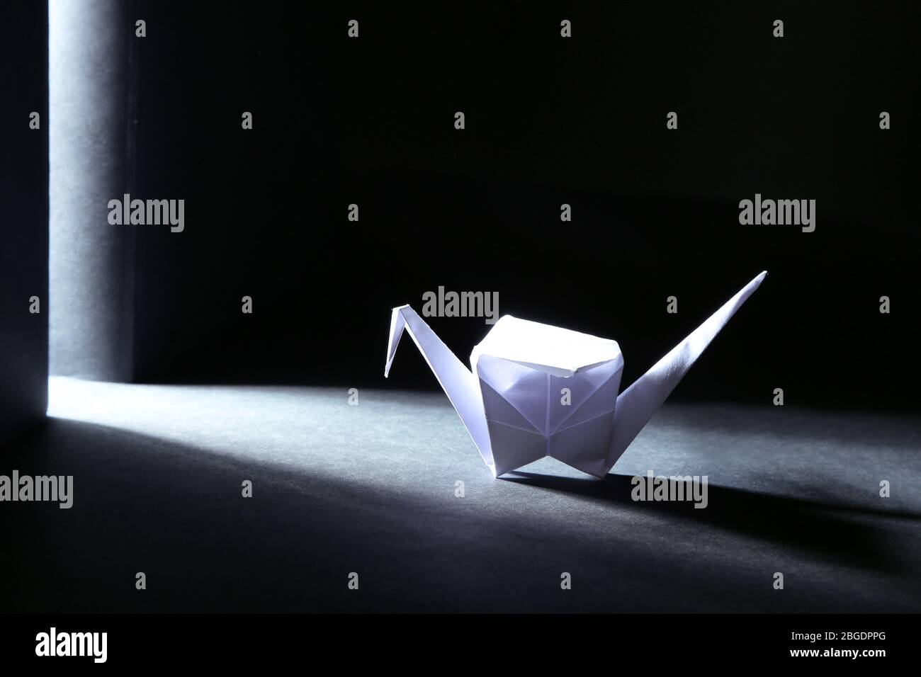 Origami crane on dark background with light Stock Photo - Alamy