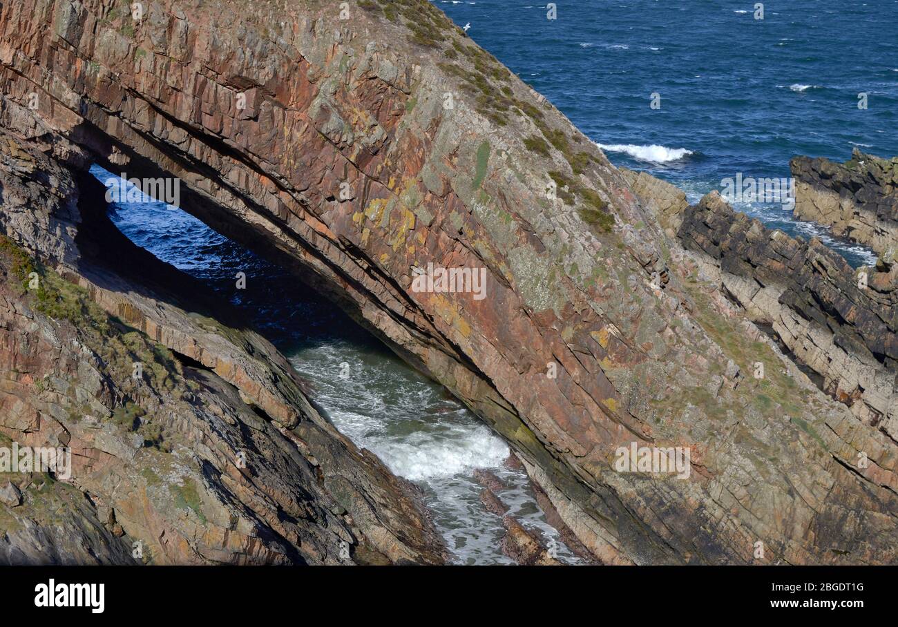 PORTKNOCKIE MORAY FIRTH SCOTLAND SEA STACK KNOWN AS THE WHALES MOUTH WITH AN INCOMING TIDE Stock Photo