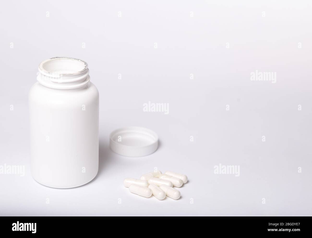 White box for medicines with no logo and capsules on a white background. Stock Photo
