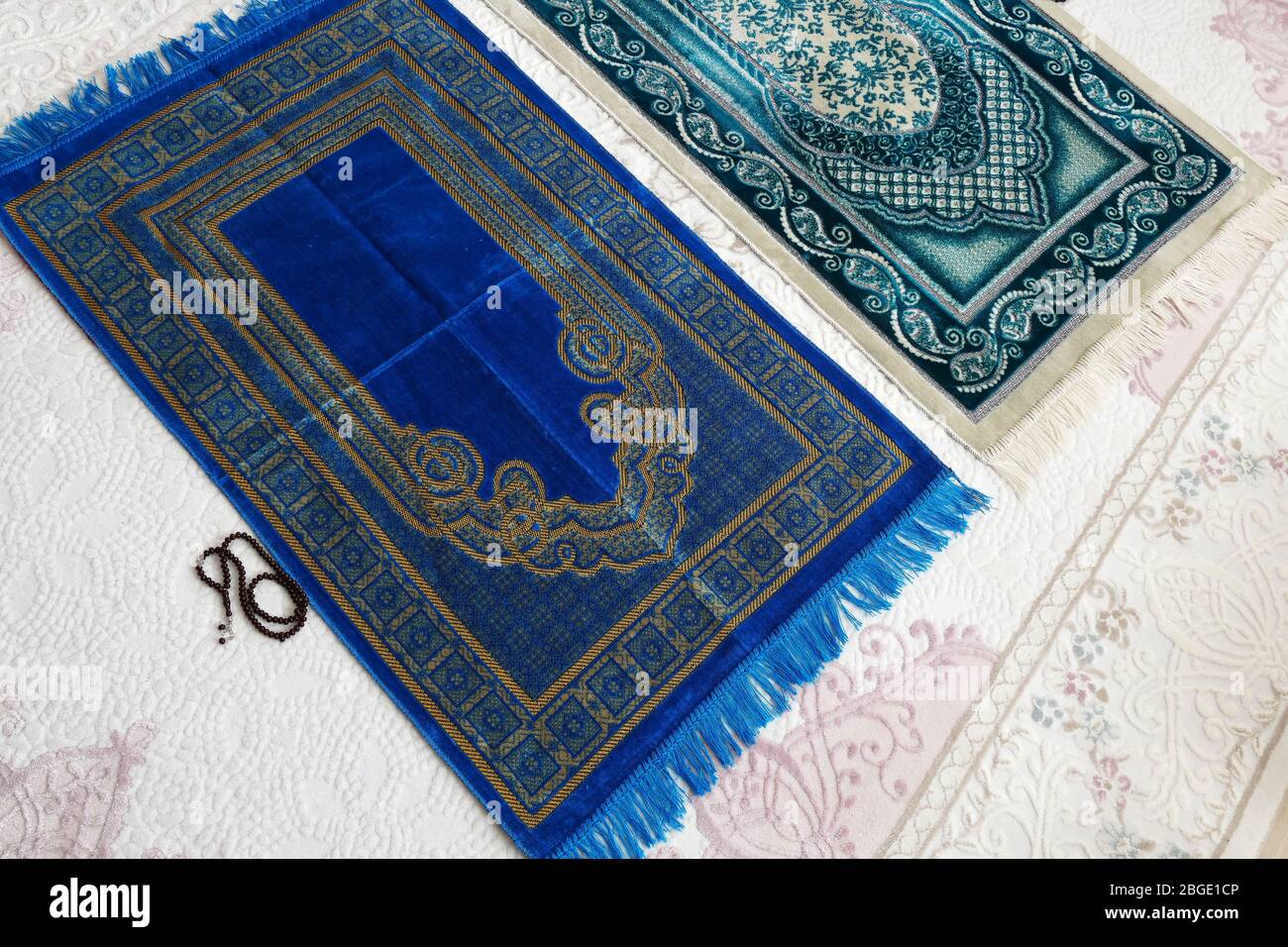 prayer rugs in two different colors prepared for prayer Stock Photo - Alamy