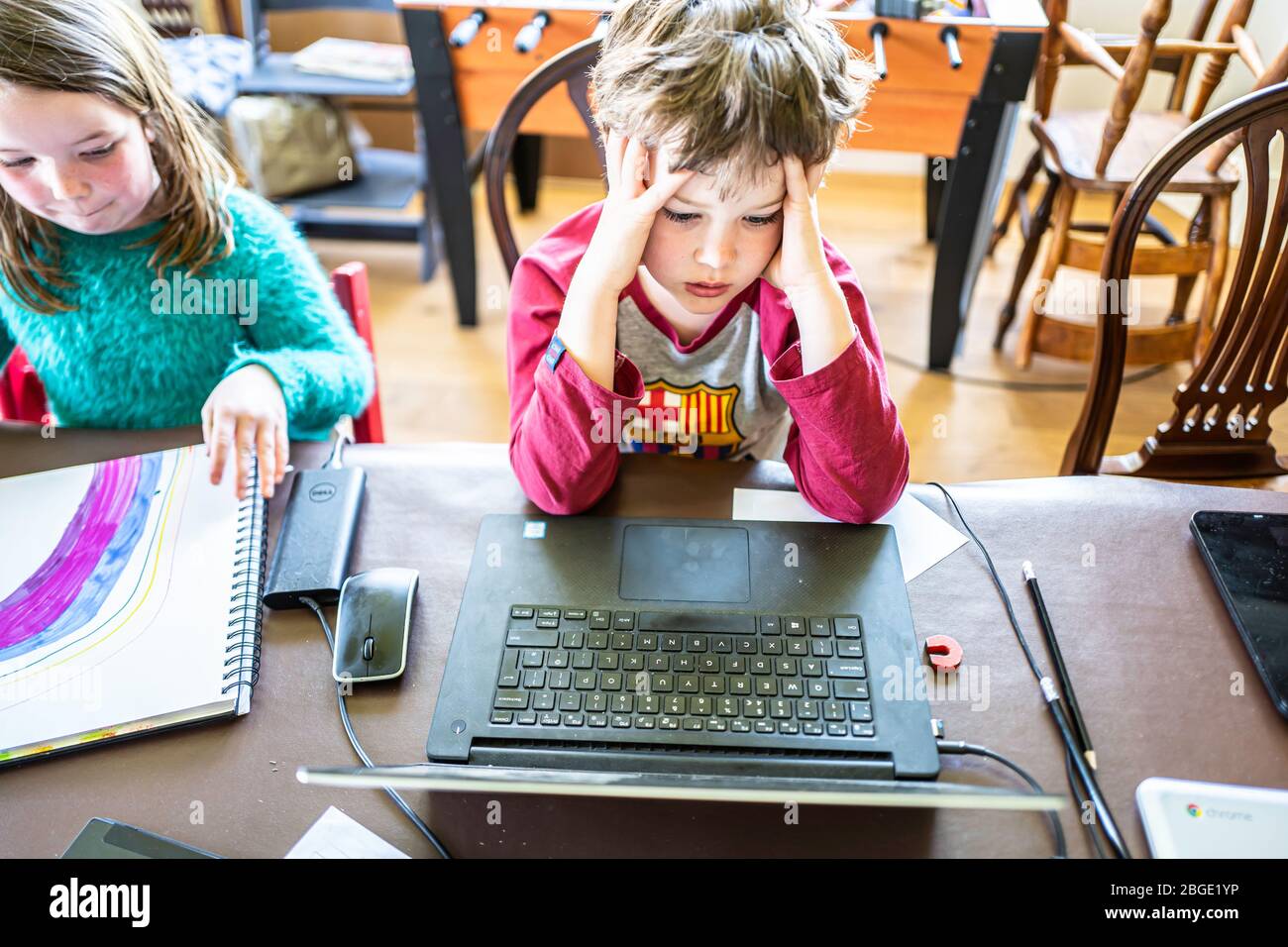 Camptown, Jedburgh, Scottish Borders, UK. 15th April 2020. Max and Lizzie Scott, 9 and 7, are being taught online by their school St. Mary's of Melros Stock Photo