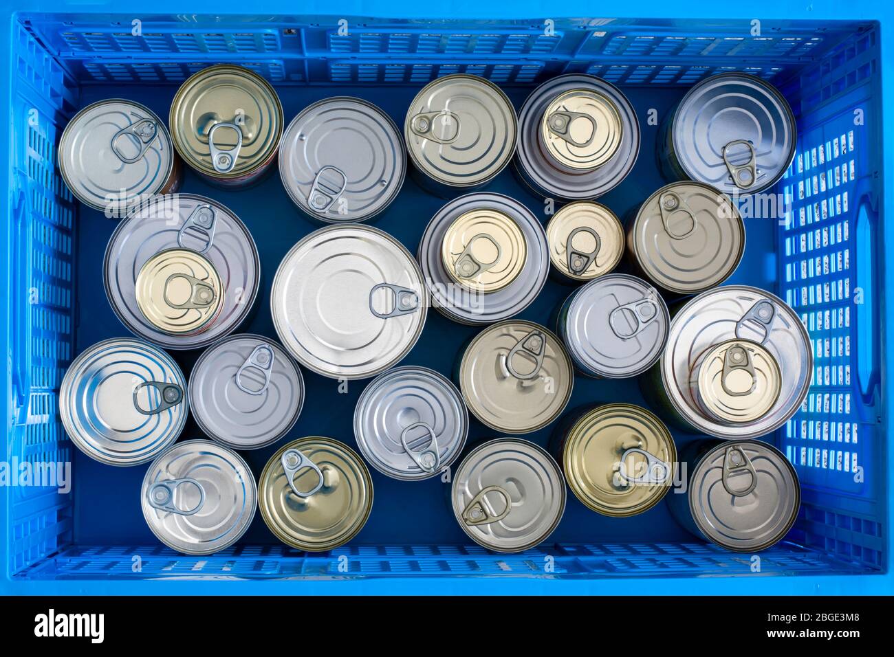Lots of canned food in different sizes. Preserved food in collapsible crate grocery store packing container. Hoarding food as a quarantine stock Stock Photo