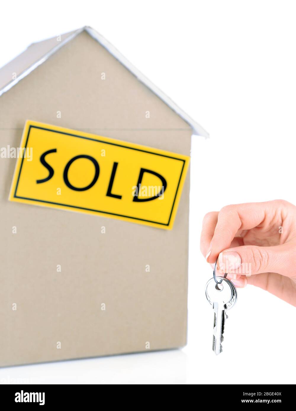 Hand holding keys cardboard house isolated on white Stock Photo - Alamy