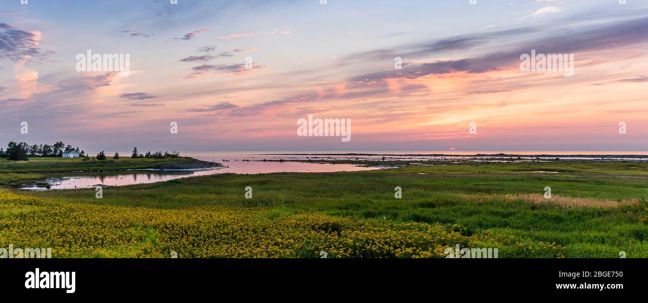 A beautiful pink warm sunset on the south shore of the Saint Lawrence River in Matane, a little town on the Gaspé Peninsula, Quebec, Canada Stock Photo