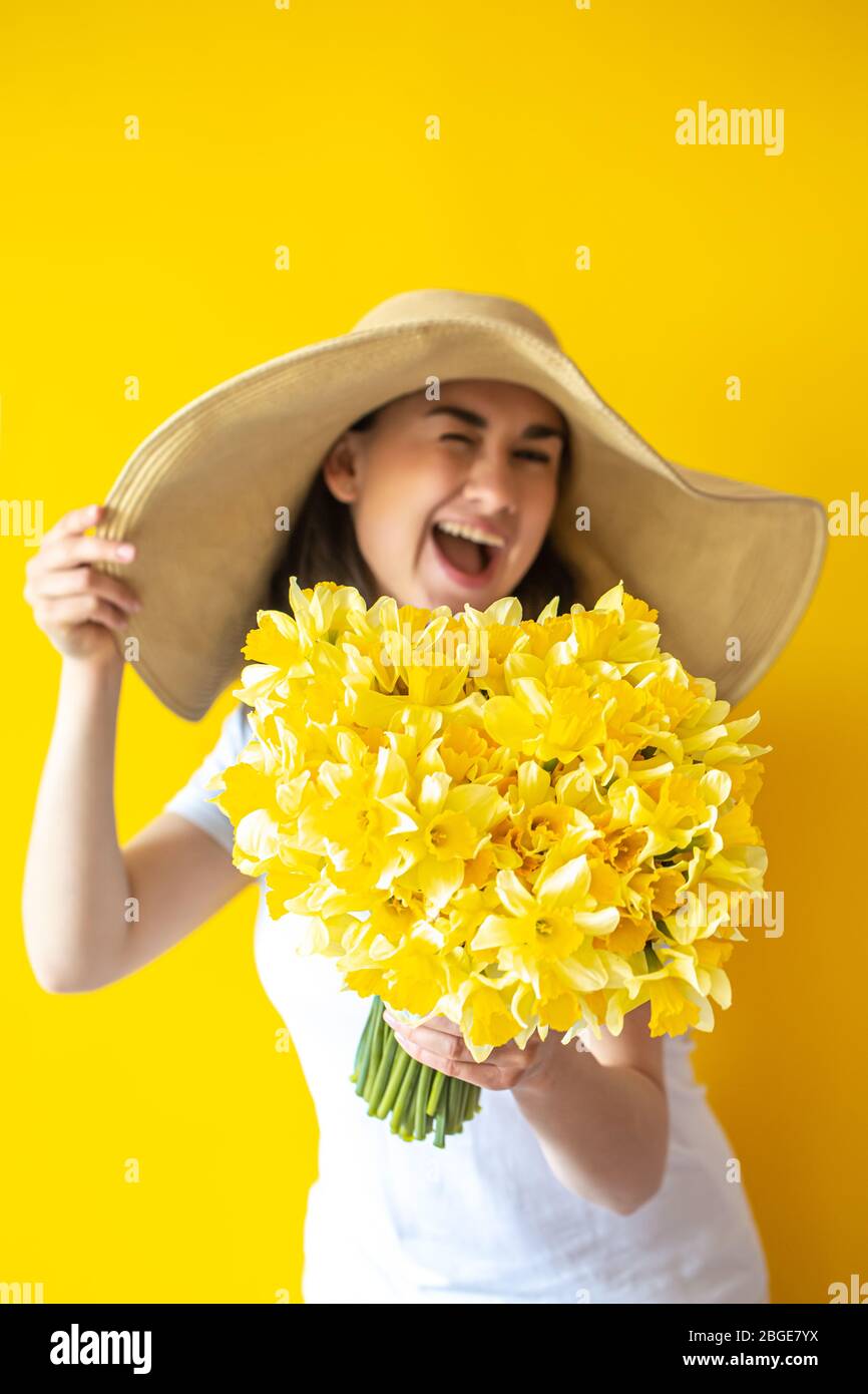 A young woman in a hat with a bouquet of flowers Stock Photo - Alamy