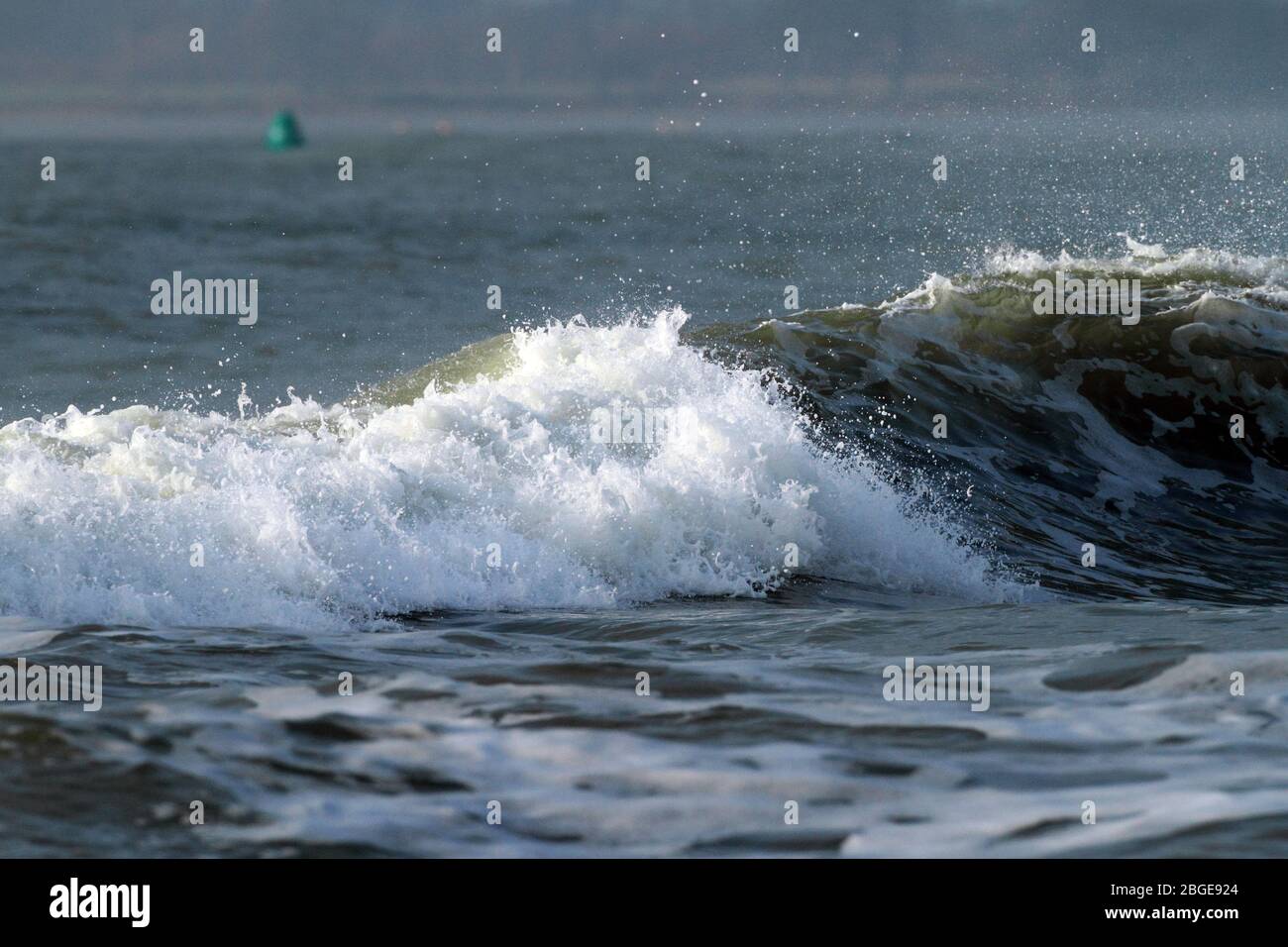 A wave rolls through Chichester Harbour, West Sussex, England. Stock Photo