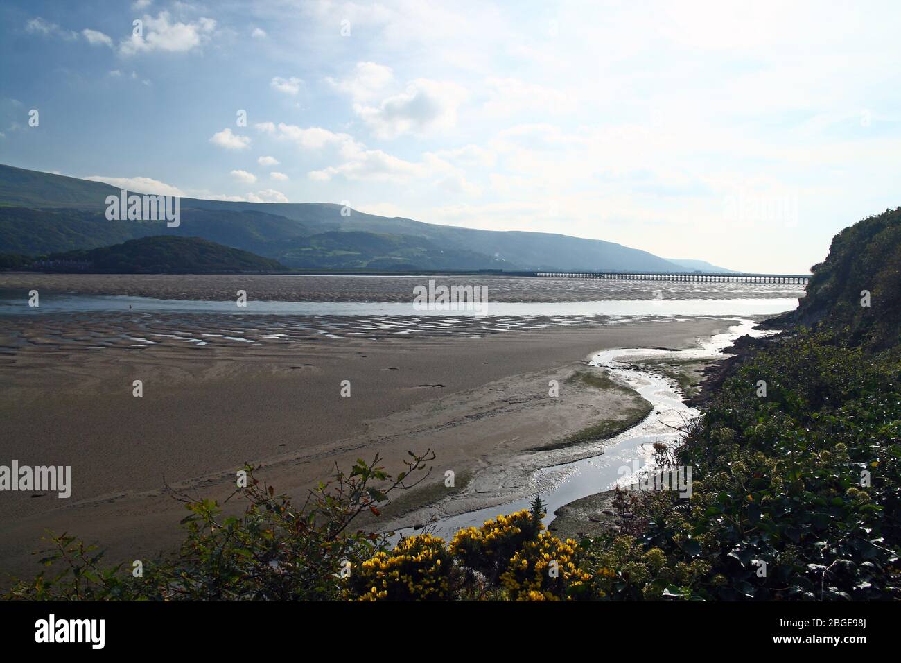 A view down the Mawddach Estuary in Gwynedd, Wales towards the Barmouth Railway Viaduct. Originally made of timber, it was built in 1867. Stock Photo