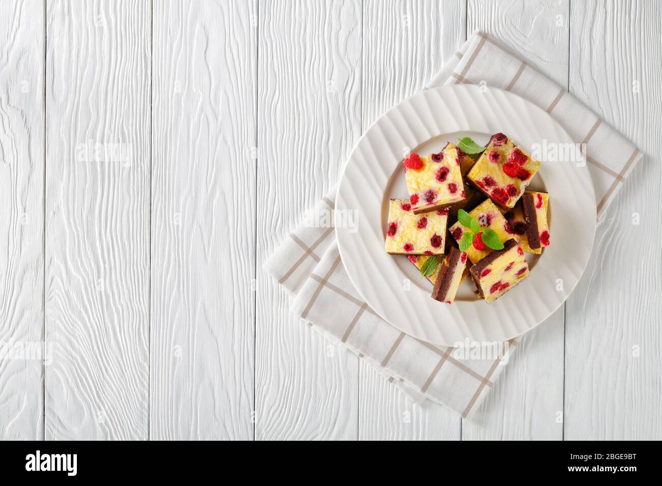 delicious vegetarian Raspberry Cheesecake Bars on a white plate, flat lay, horizontal view from above, free space Stock Photo