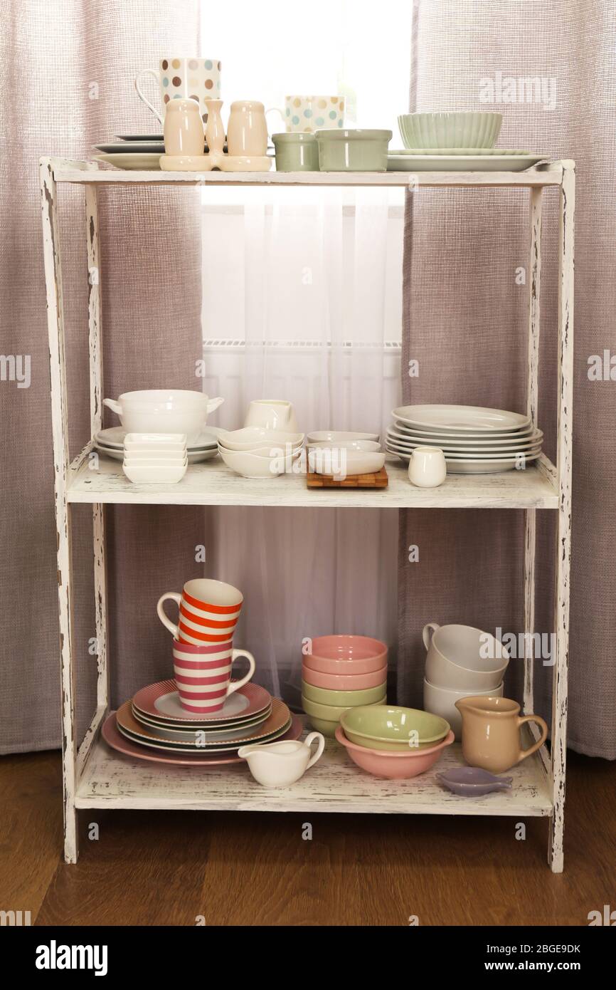 Different tableware on shelf in the interior Stock Photo