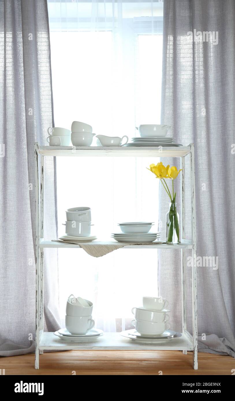 Different tableware on shelf in the interior Stock Photo