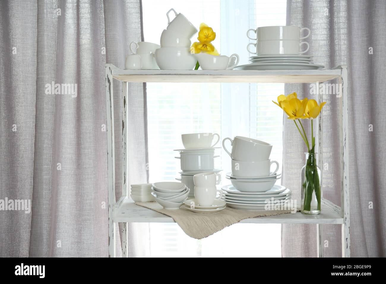 Different tableware on shelf in the interior Stock Photo