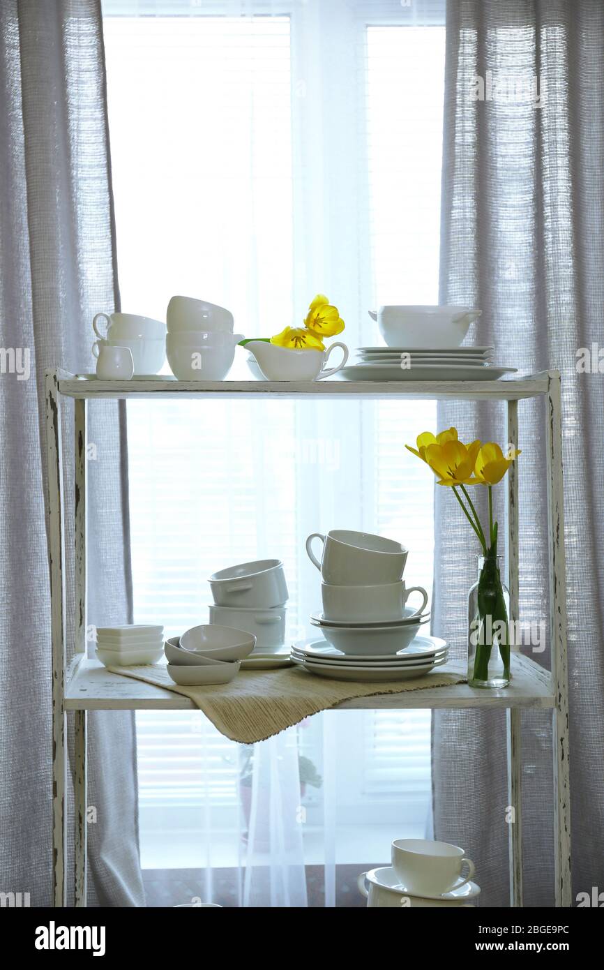 Different tableware on shelf in the interior Stock Photo