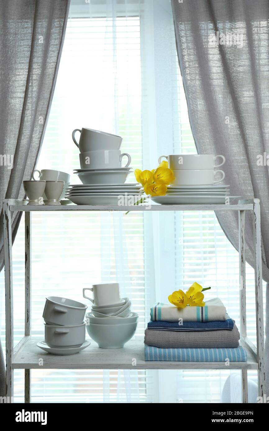 Different tableware on shelf in the interior Stock Photo
