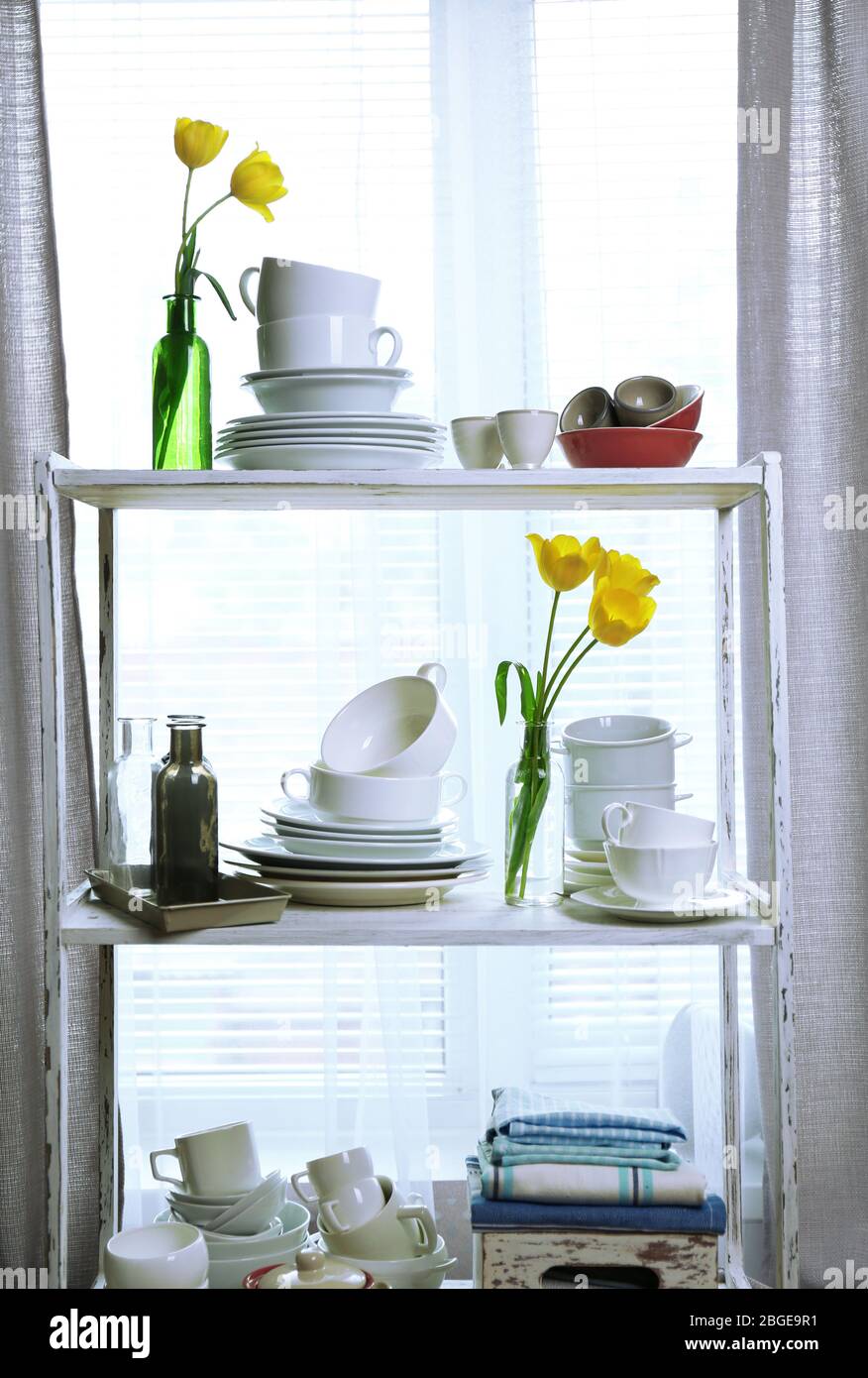 Different tableware on shelf in the interior Stock Photo
