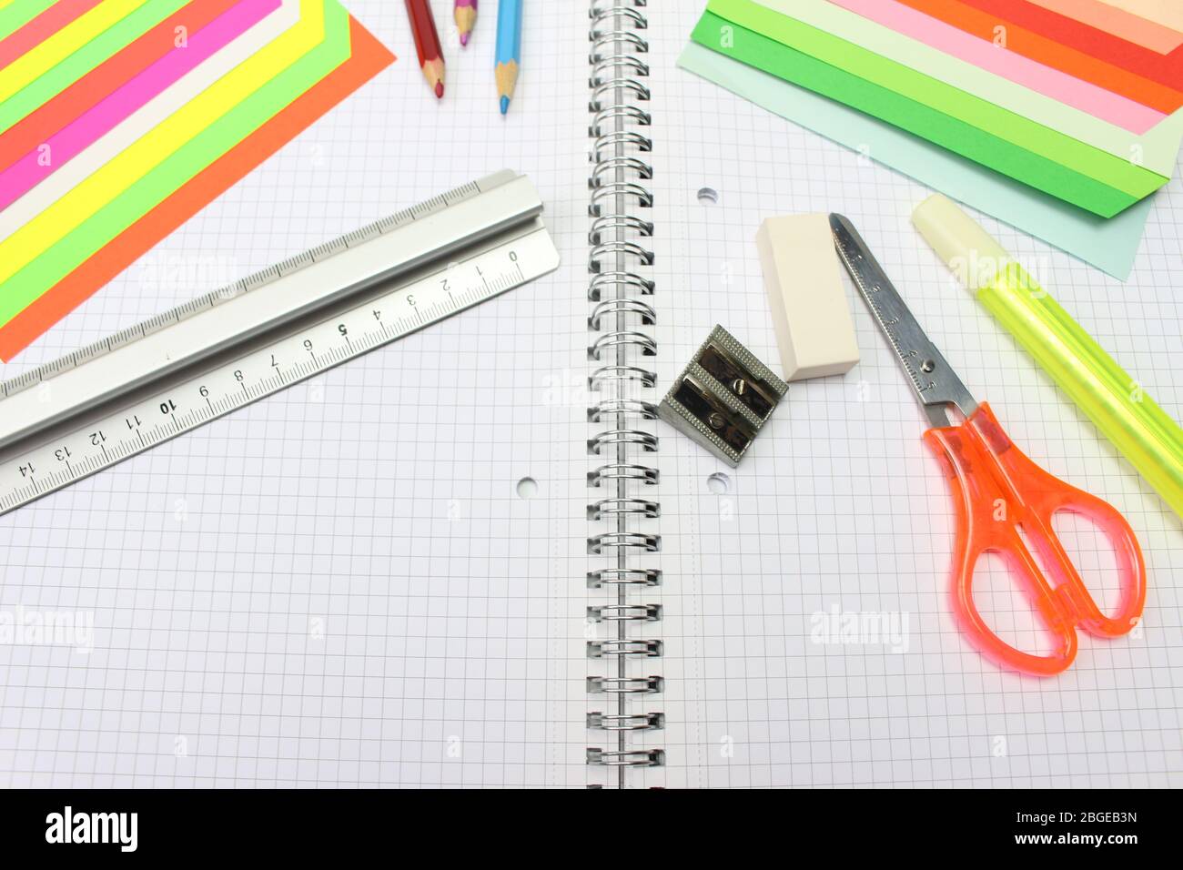 On the desk the school supplies with a spiral block and colored sheets. Stock Photo