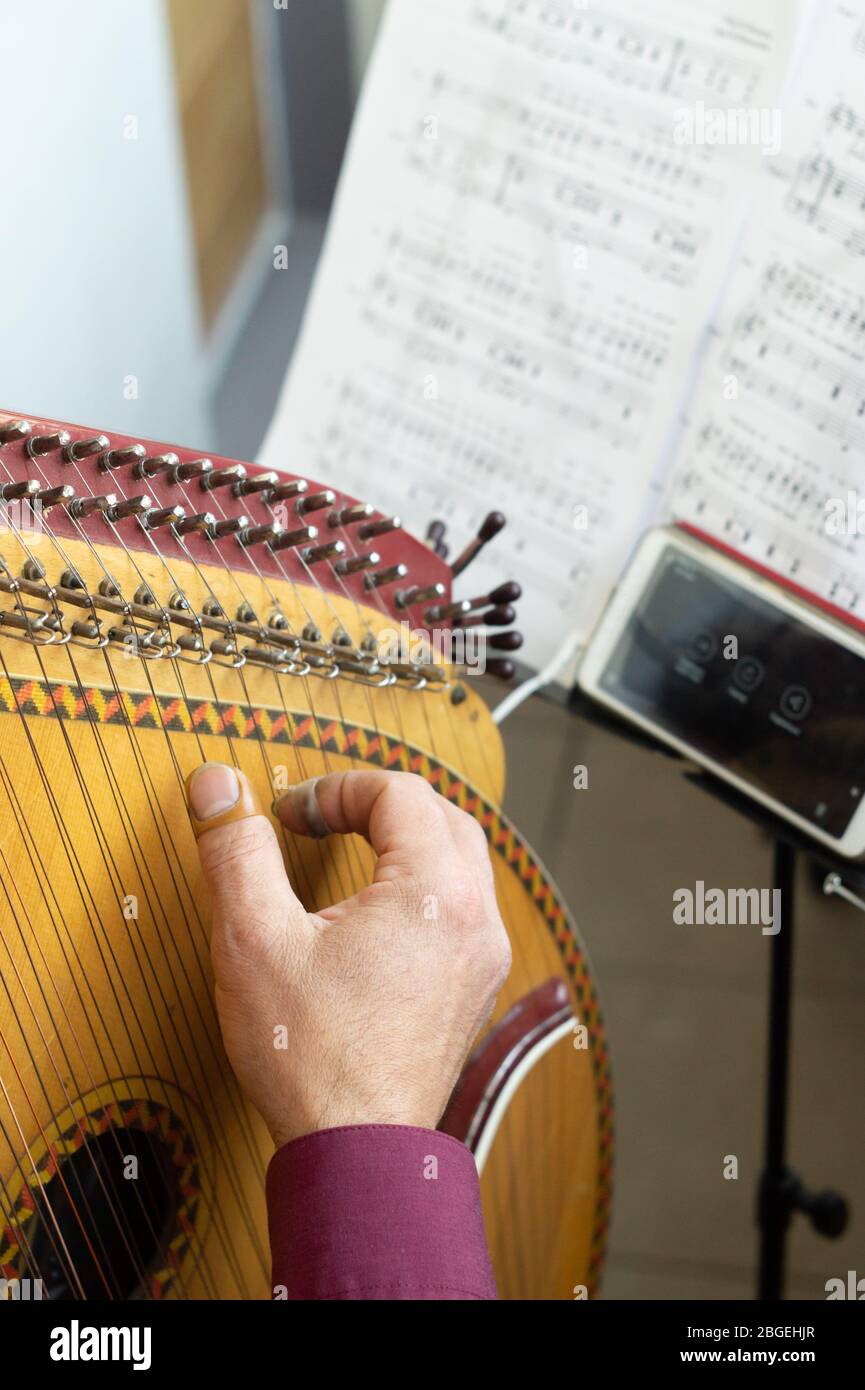 Male musician playing the bandura, rehearsing at home. Pandora is a  traditional Ukrainian musical instrument Stock Photo - Alamy