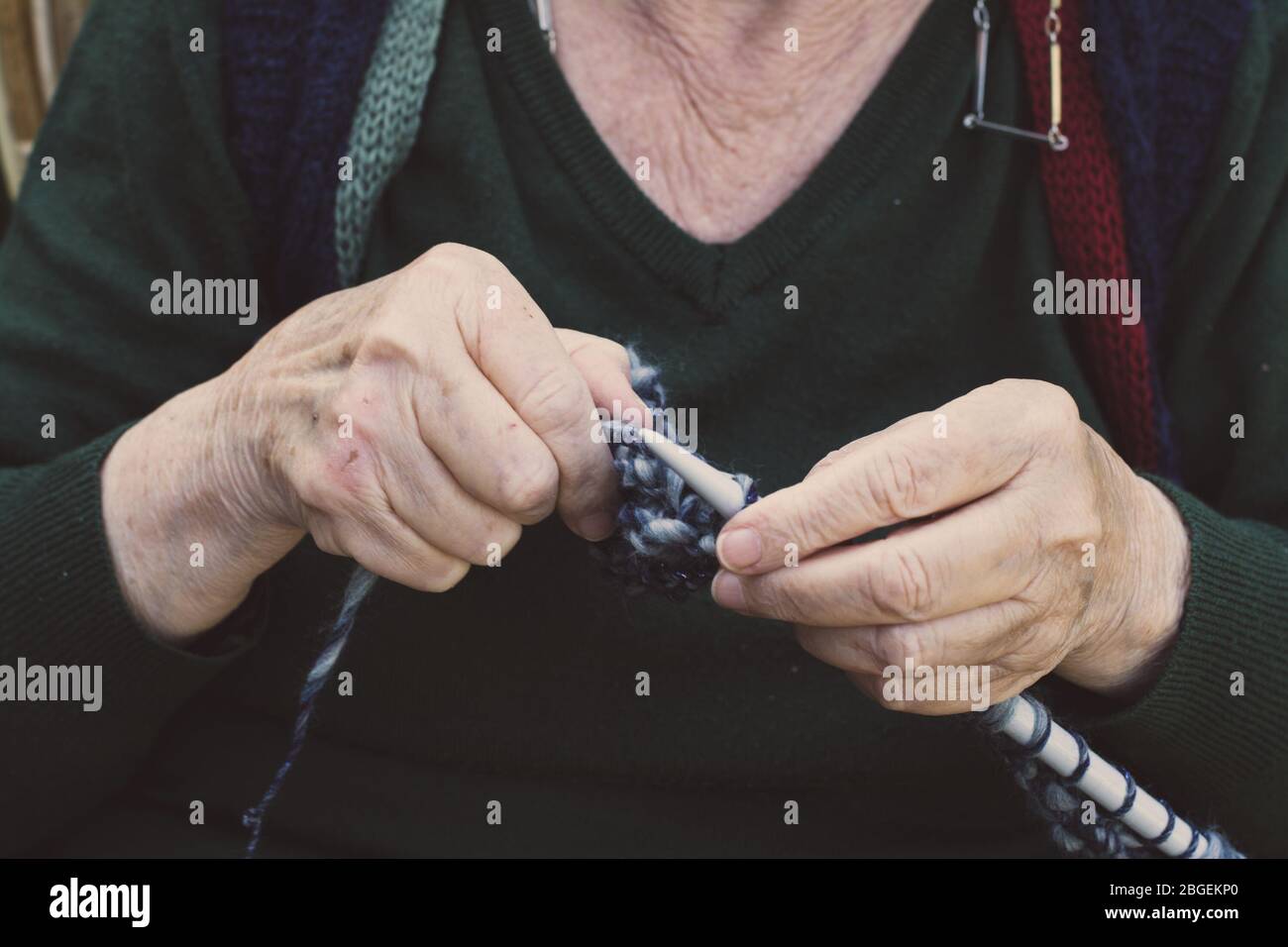 closeup on old lady hands to knitting in a terrace Stock Photo