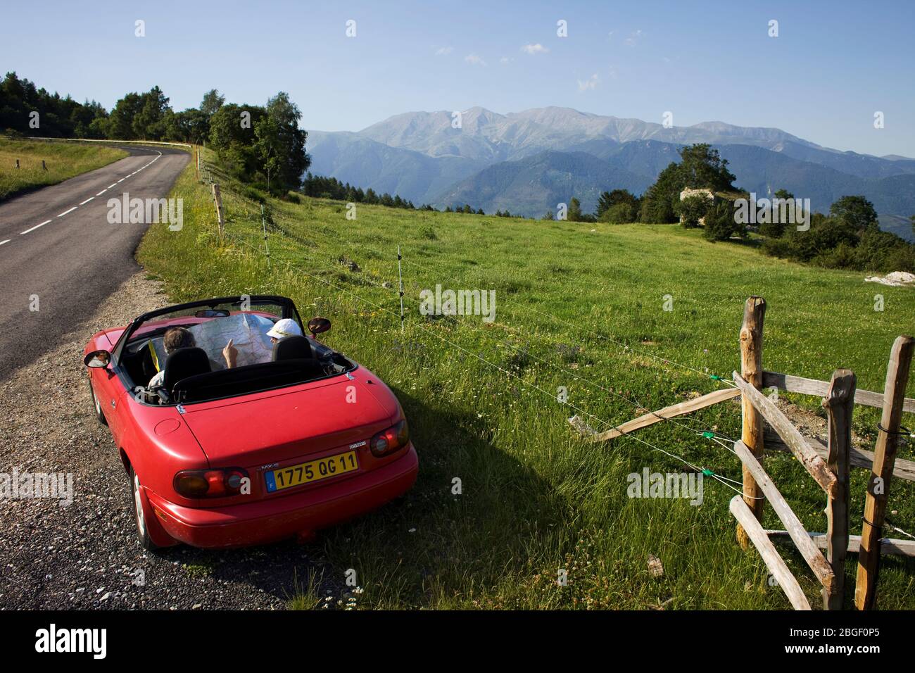 Red car in Coll d'Ares with Canigó peak at distance. Pyrenees, Catalonia, Catalogne (France, Europe) Stock Photo
