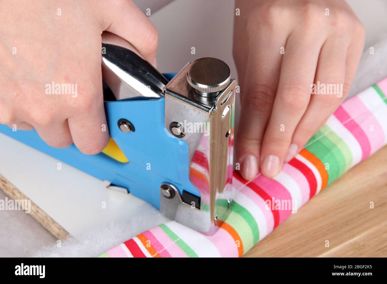Fastening fabric and board using construction stapler Stock Photo Alamy