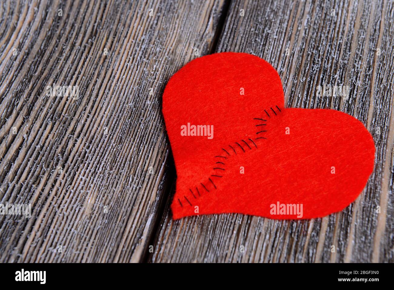 Broken heart and thread on wooden background Stock Photo