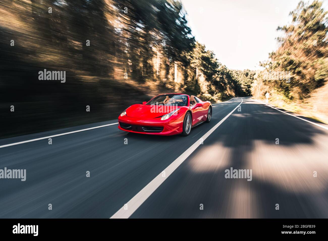 Red sport car on the racing trace in the forest in a sunny day Stock ...