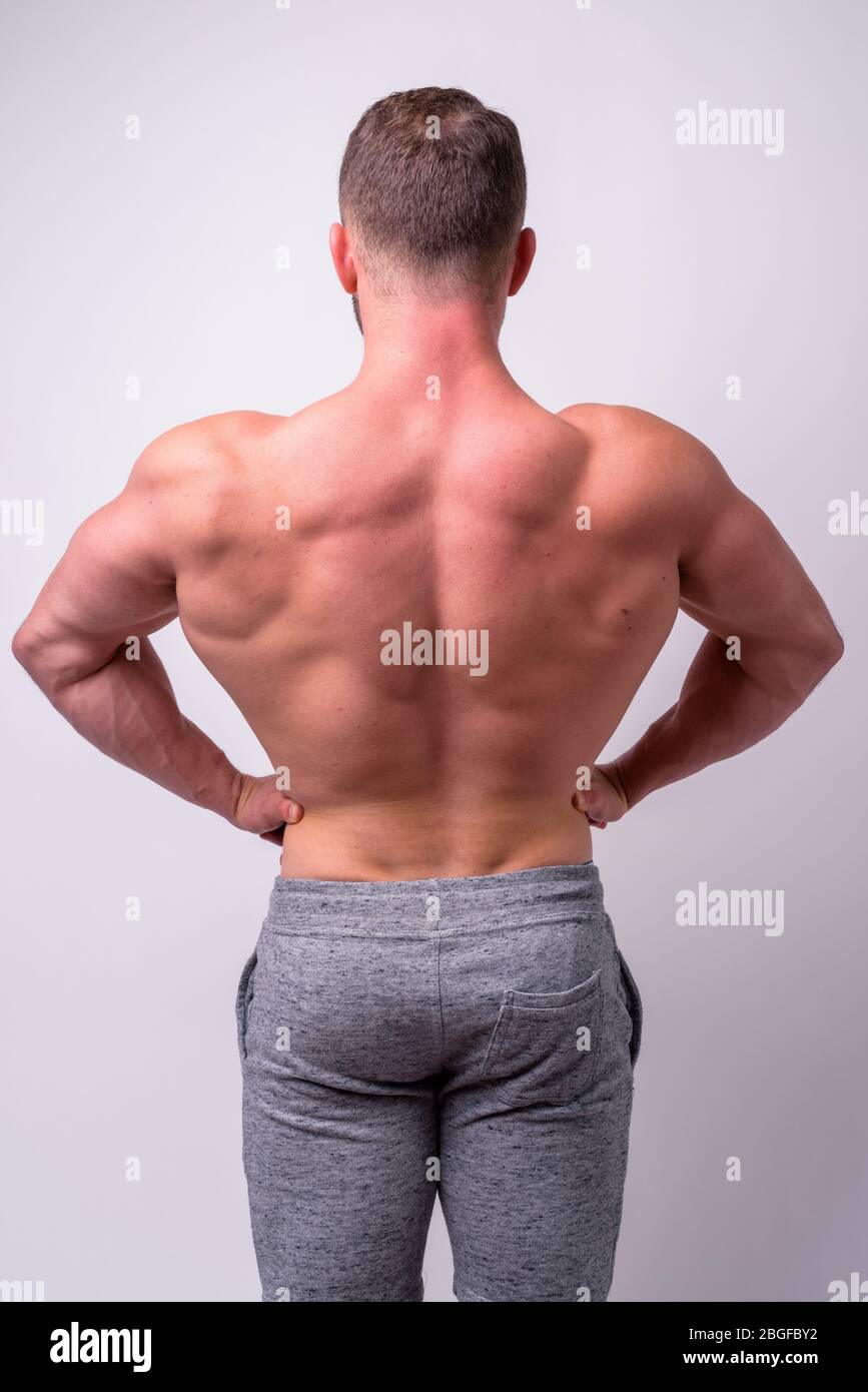 Rear view of muscular man showing back muscles shirtless Stock Photo - Alamy