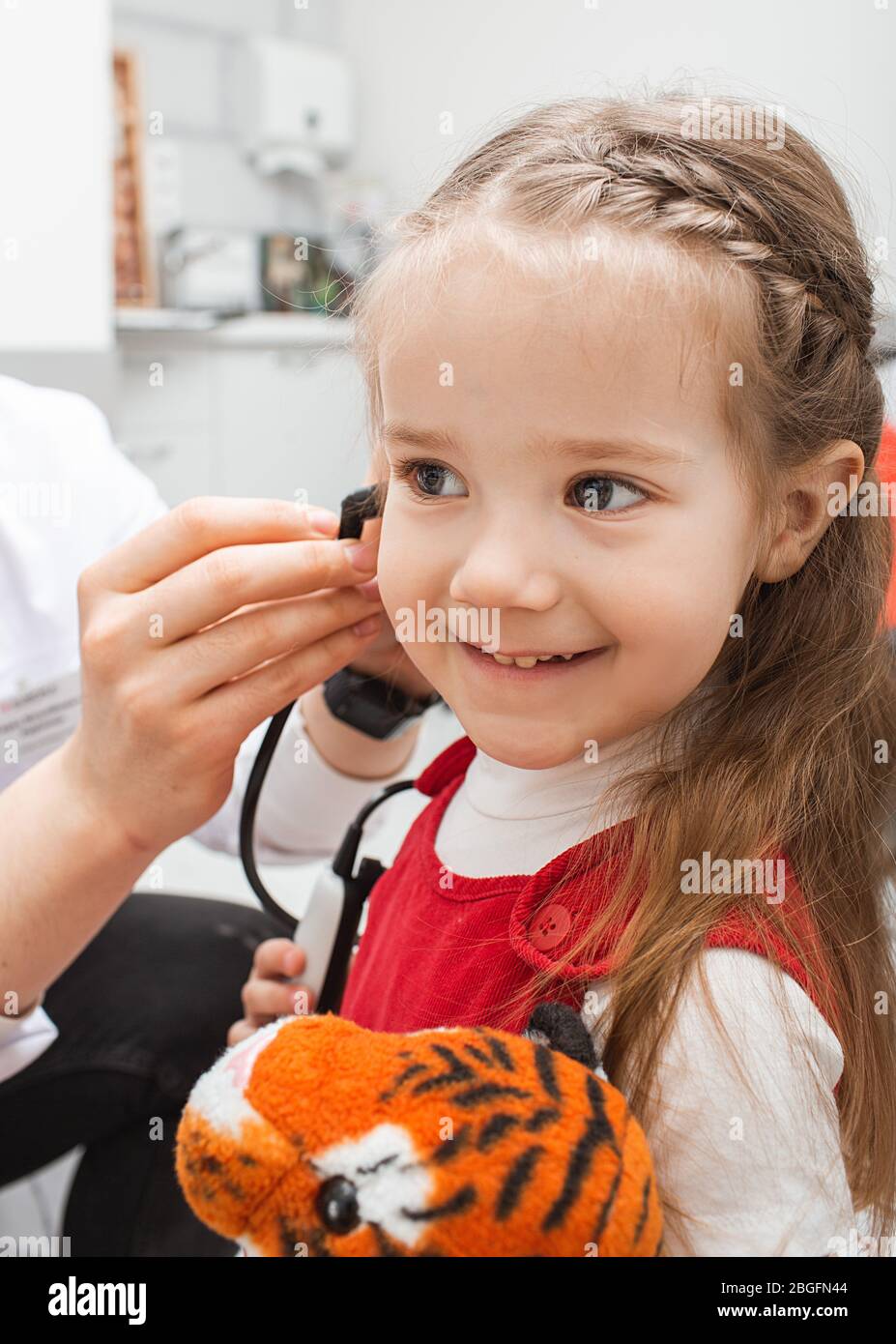 Beautiful little patient girl in audiologist office at hearing clinic. Children's hearing