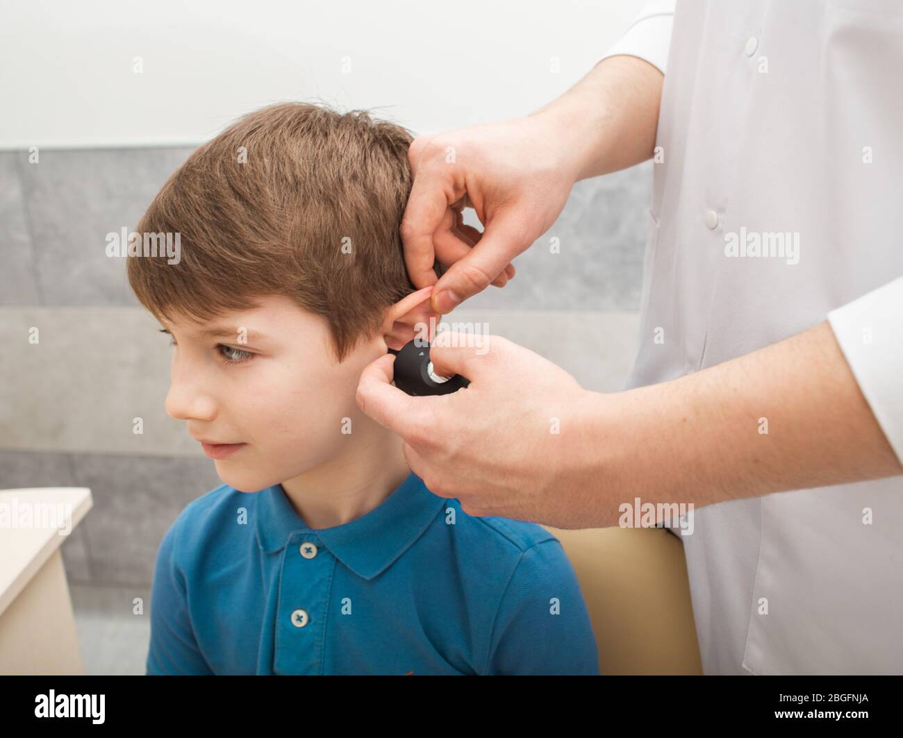 Otolaryngologist doing a hearing exam in a boy. Tympanometry measures