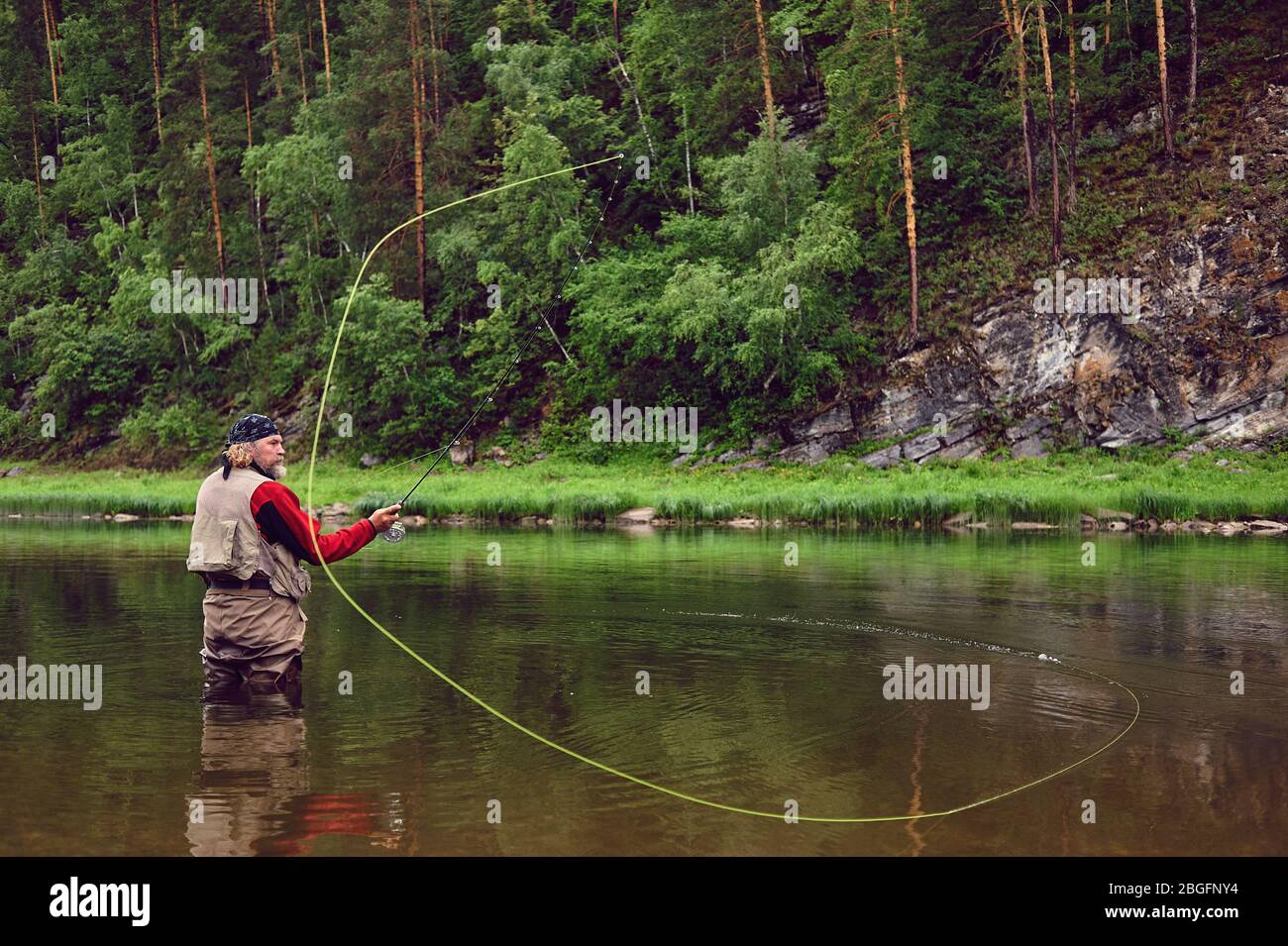 fly fishing angler makes cast while standing in water Stock Photo Alamy