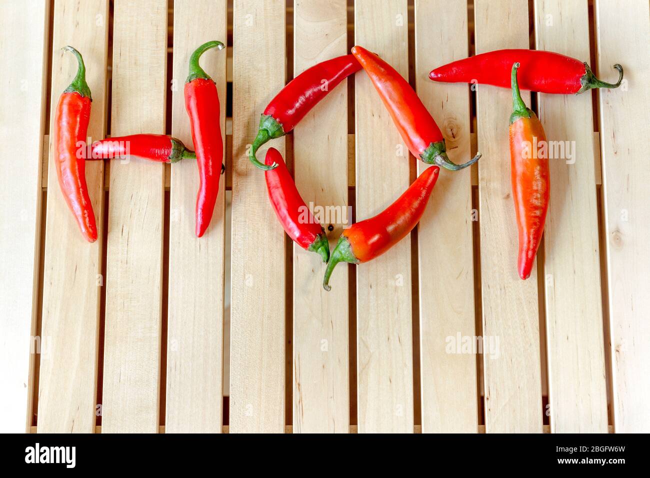 Word 'Hot' made by some red hot chilli peppers. Stock Photo