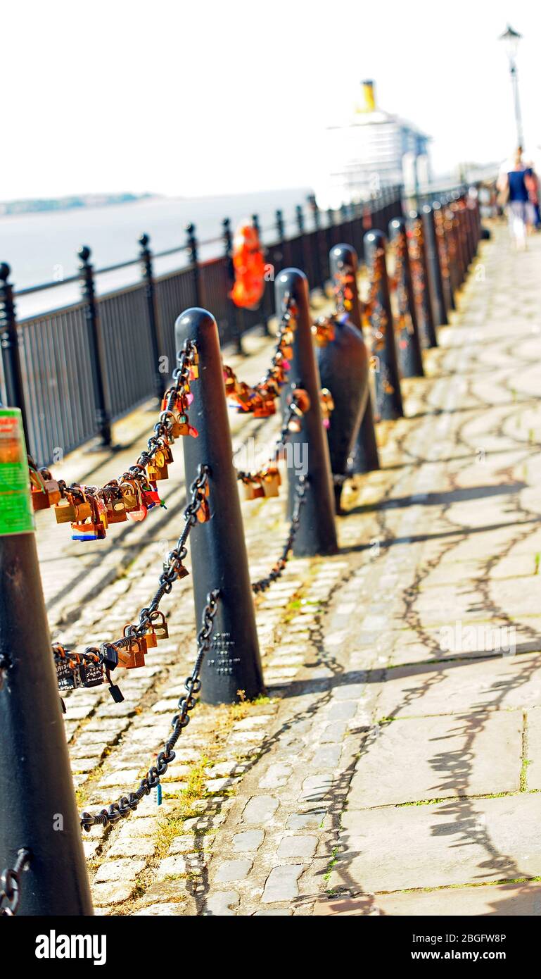 Love locks attached to chain link barrier on Albert Dock in Liverpool Stock Photo