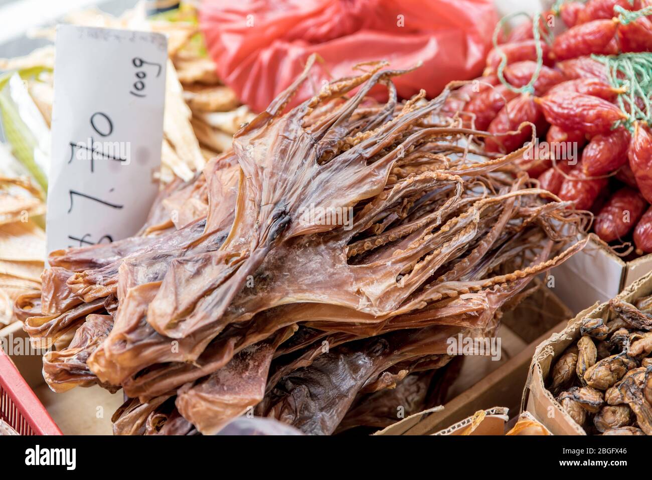 Dried squid skin for sale in basket with price tag. Oriental, crispy