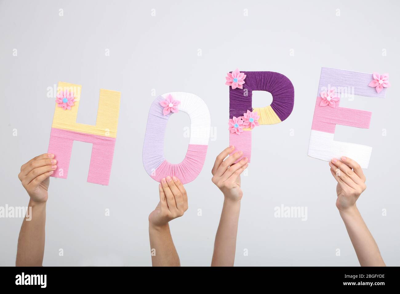 Hope In Letters Hands holding up letters building word hope on grey background Stock ...