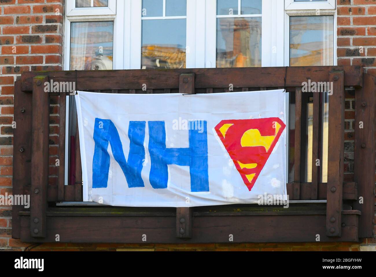 Wyke Regis, Weymouth, Dorset, UK.  21st April 2020.  A banner supporting the NHS with a superman symbol hangs outside a house at Wyke Regis in Dorset during the continued coronavirus pandemic lockdown.  Picture Credit: Graham Hunt/Alamy Live News Stock Photo