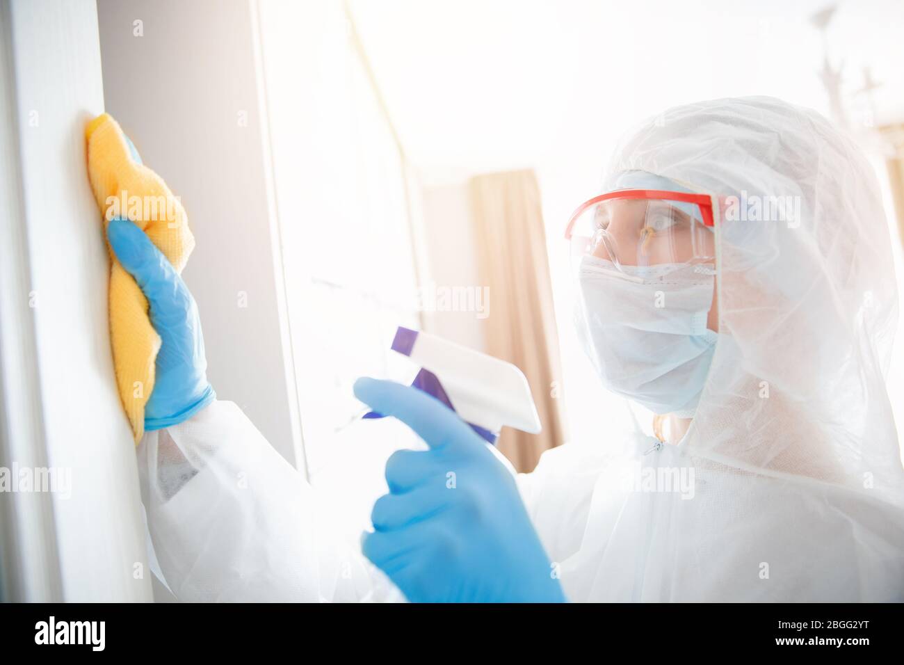 Disinfection and cleaning door house from infection with virus and microbes in biochemical suit. Coronavirus protection concept Stock Photo