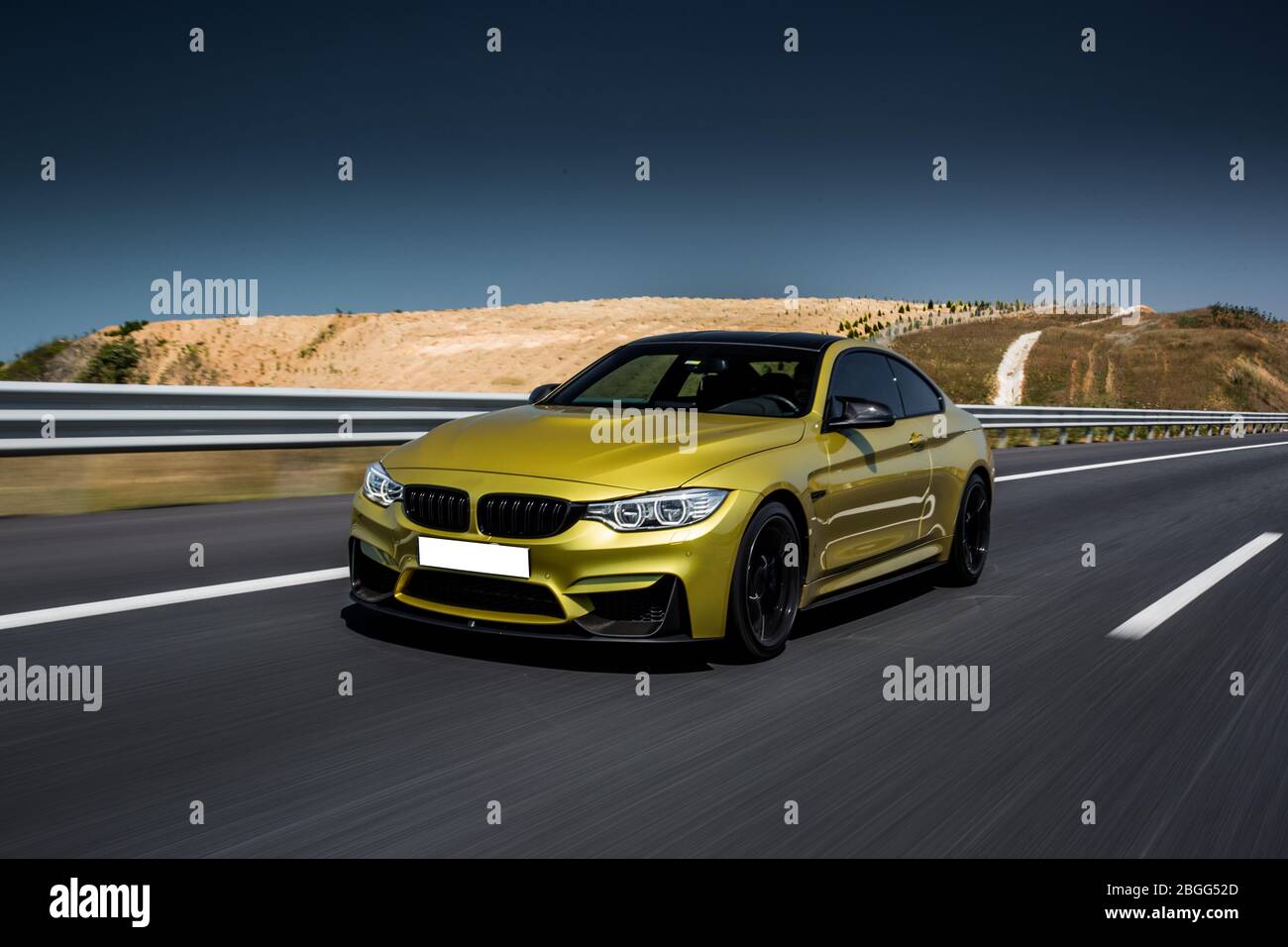 Yellow racecar travelling on the highway across deserts, front view ...