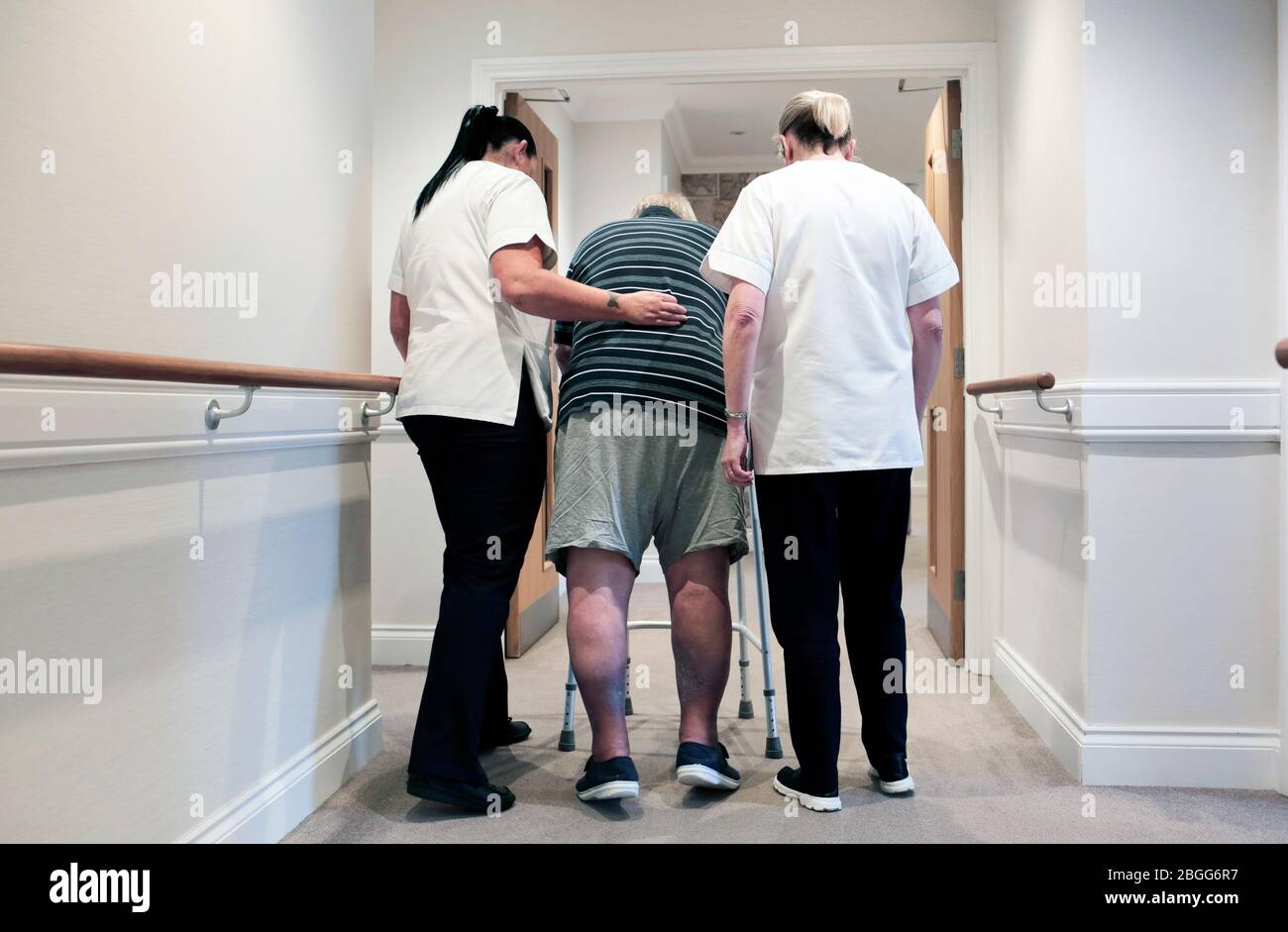Staff assist a man using a zimmer frame at a residential care home in Redcar, UK. 2/2/2018.  Photograph: Stuart Bolton. Stock Photo