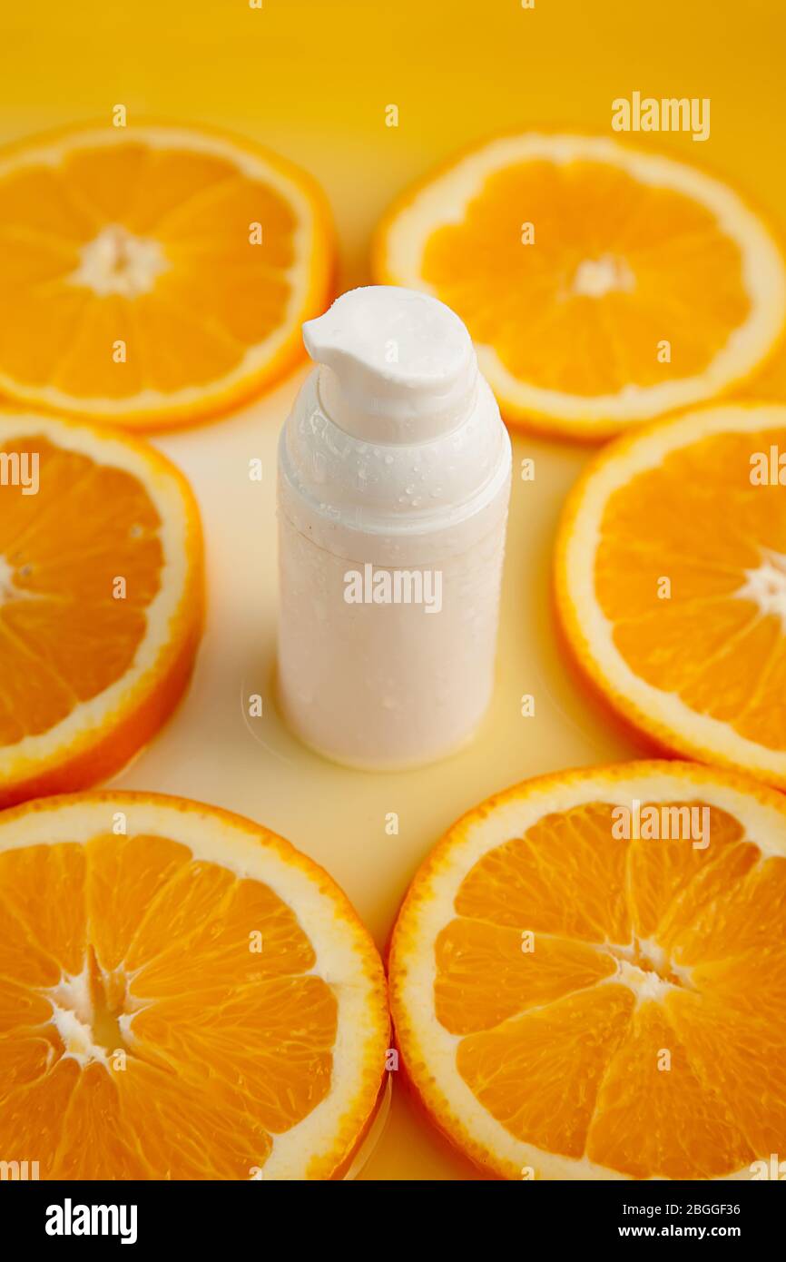 Natural cosmetic skincare serum packaging with leaf fern and fresh juicy  orange fruit on white background. Beauty vitamin ingredient. alternative  medi Stock Photo - Alamy