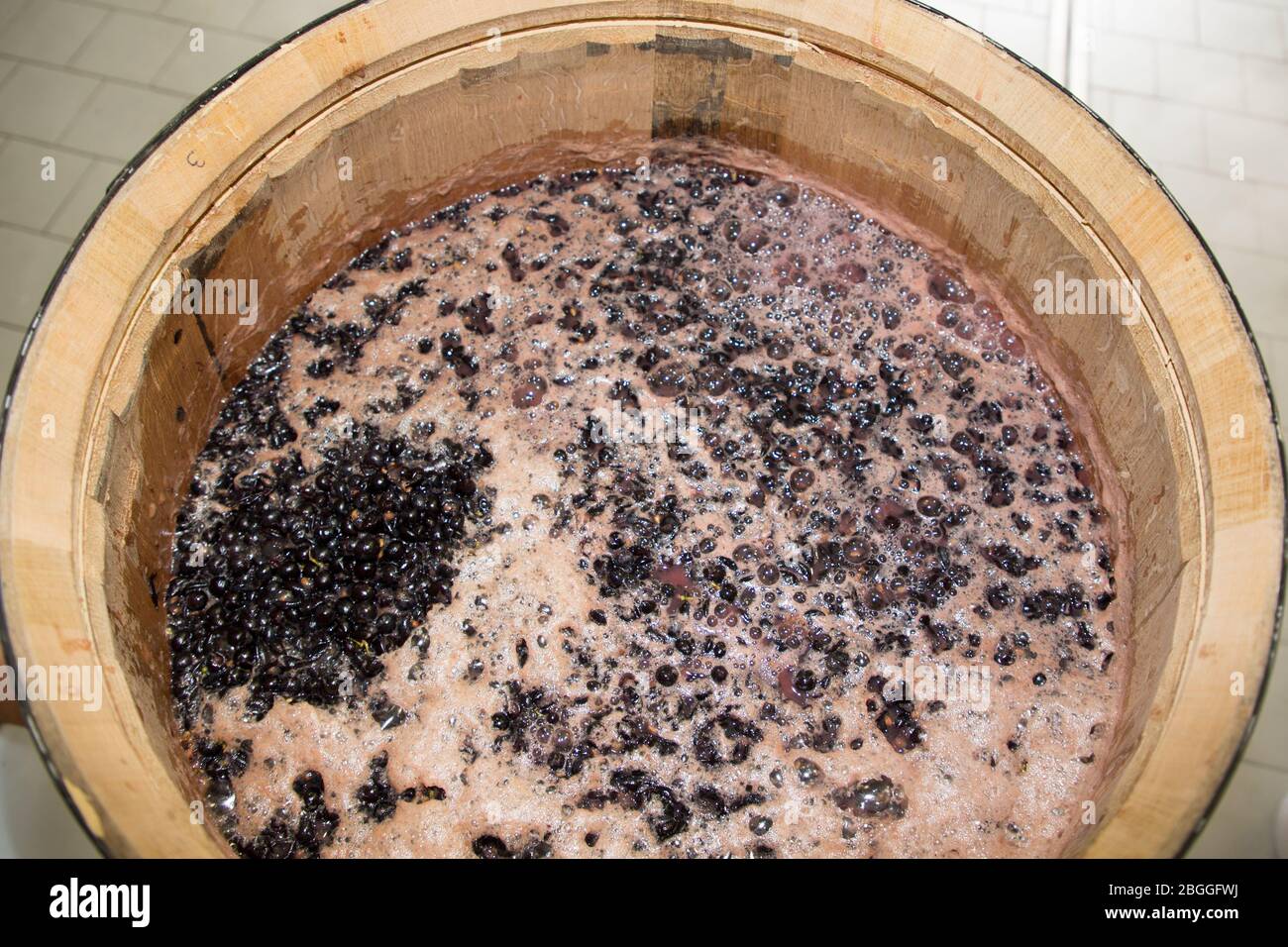 Traditional organic wine making grapes in wooden wine barrel Stock Photo