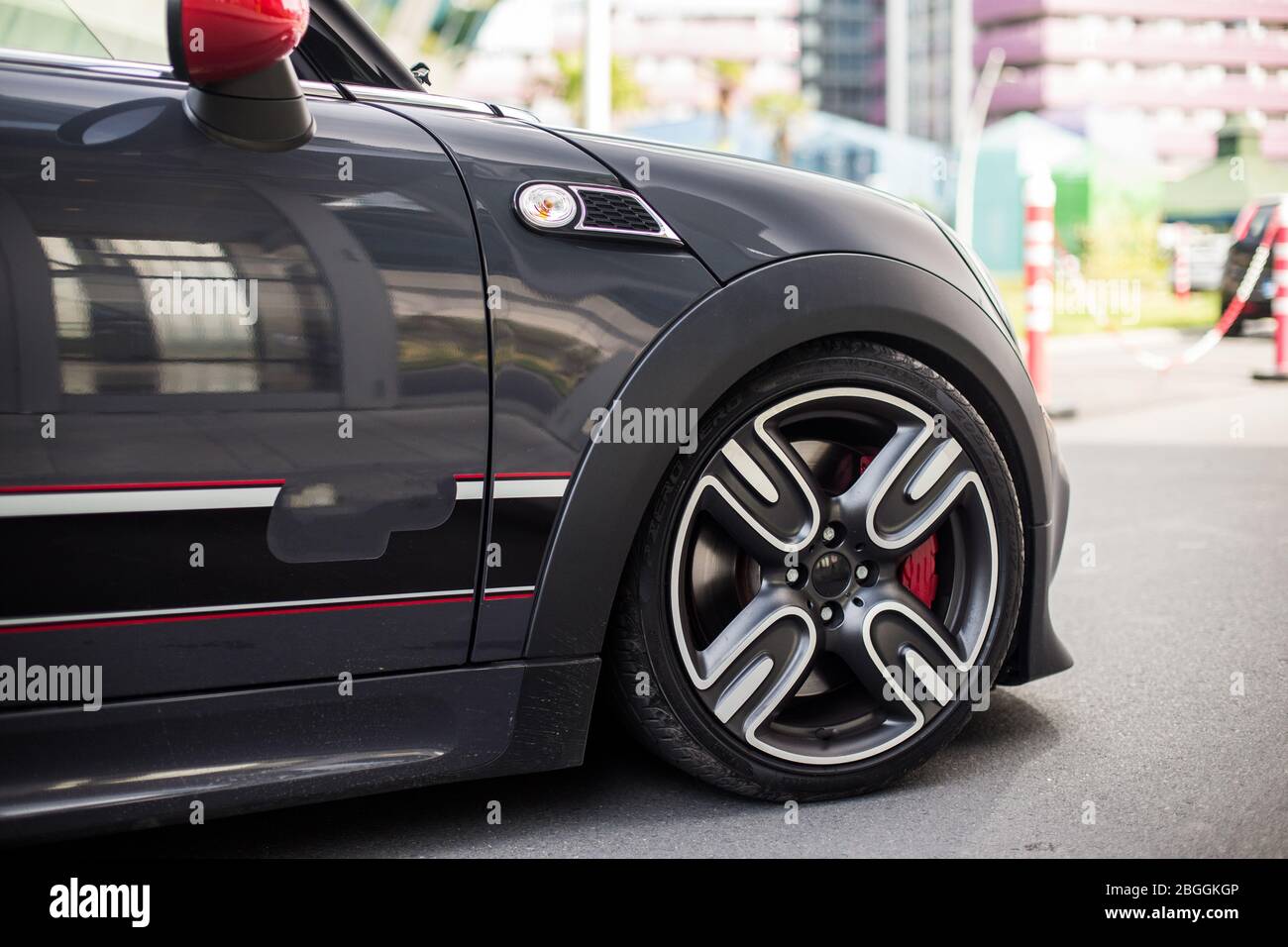 Black mini parked in front of a residence, front wheel and door Stock Photo