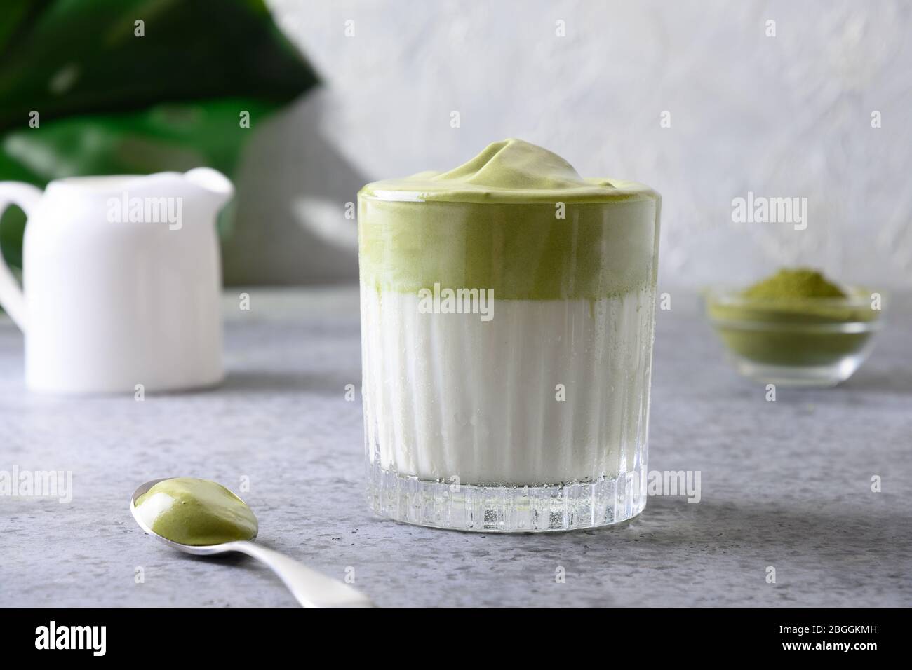 Premium Photo  Iced green tea matcha dalgona in two glasses with a straw  and a bowl of matcha powder for cooking on a wooden tray white background  space for text