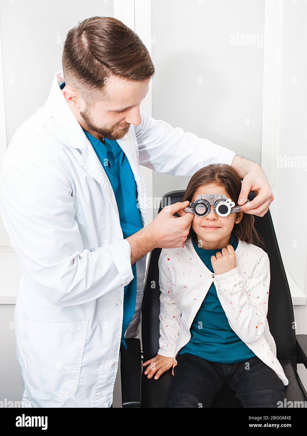 Mixed race girl in optometrist's office. doctor assistance select