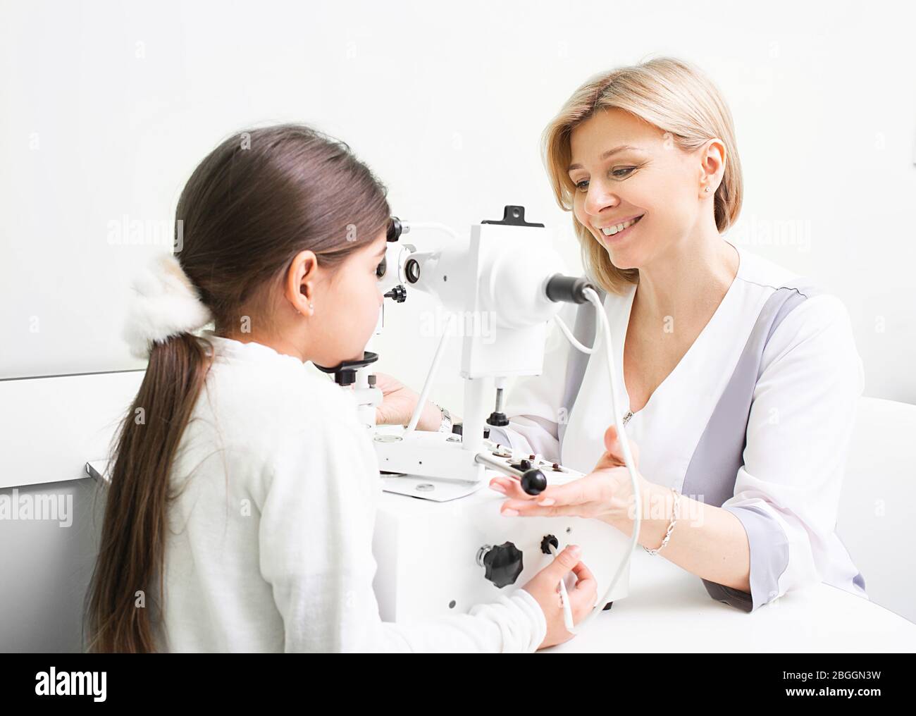 Ophthalmologist performs strabismus checkup using synoptophore. Strabismus treatment of a girl patient Stock Photo