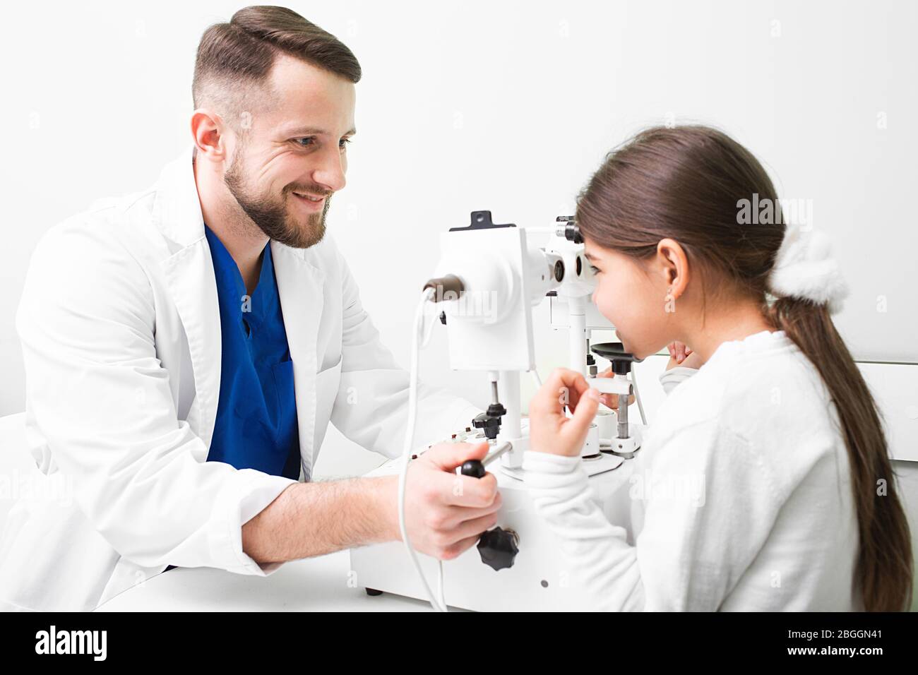 Optometrist doing strabismus checkup using synoptophore. Modern equipment in an ophthalmic clinic. Strabismus in children Stock Photo