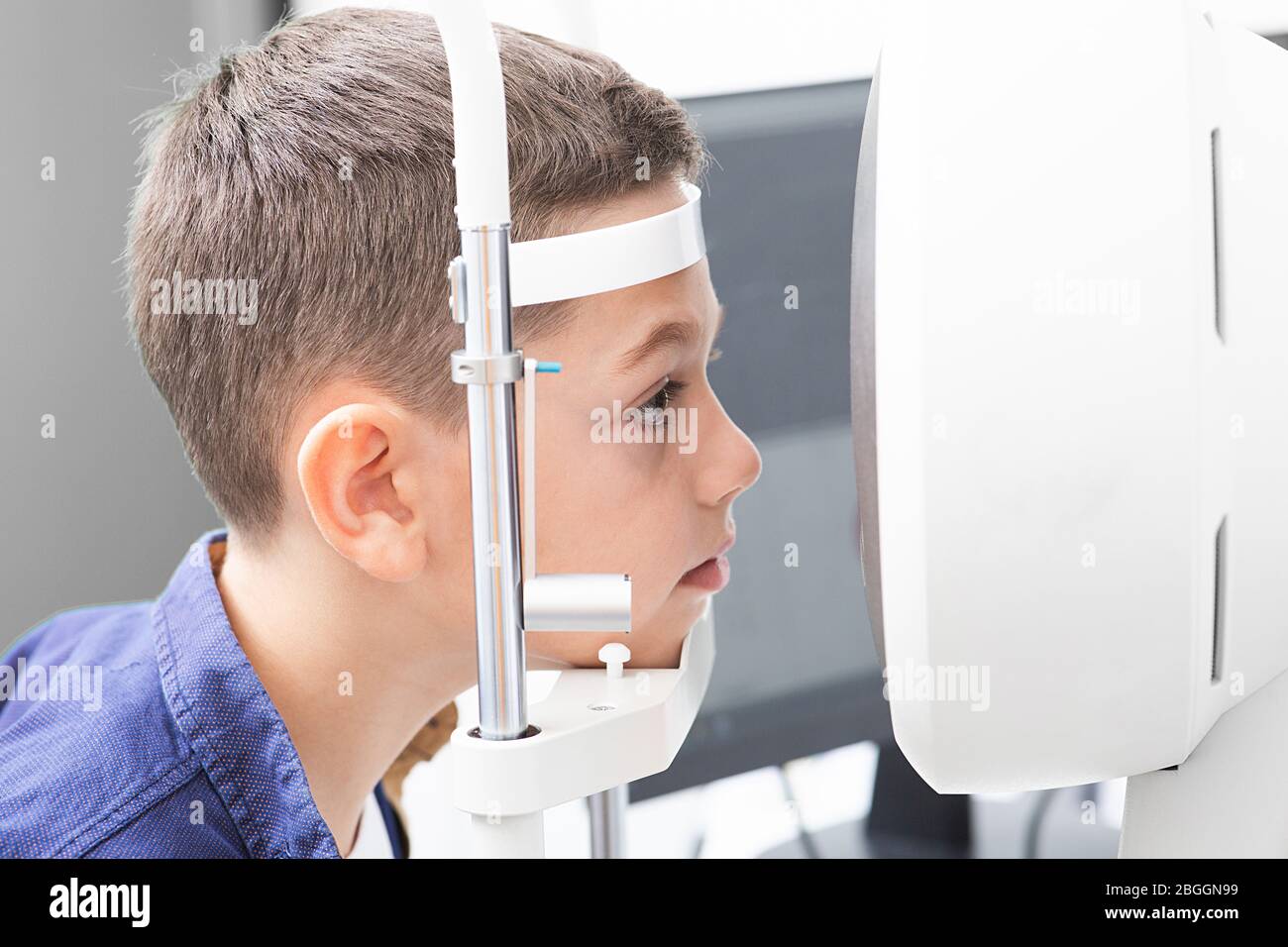Vision correction in a boy. Close-up face of patient boy. Super modern equipment in a modern clinic for eye examination Stock Photo